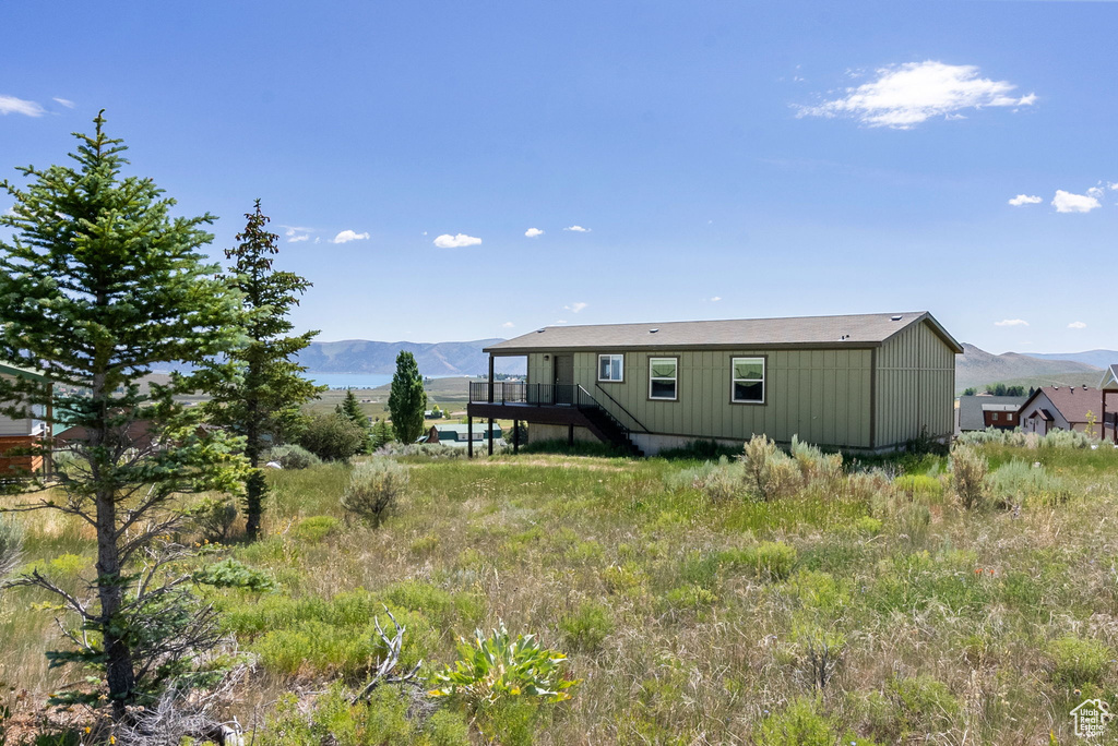 Rear view of property featuring stairs and a deck with mountain view
