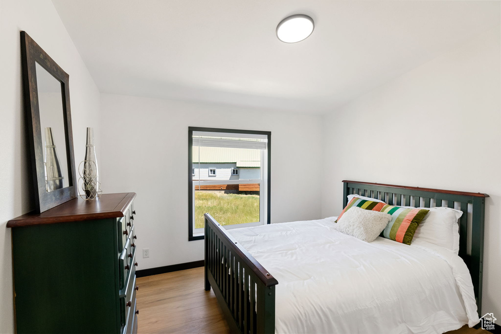 Bedroom with wood finished floors and baseboards