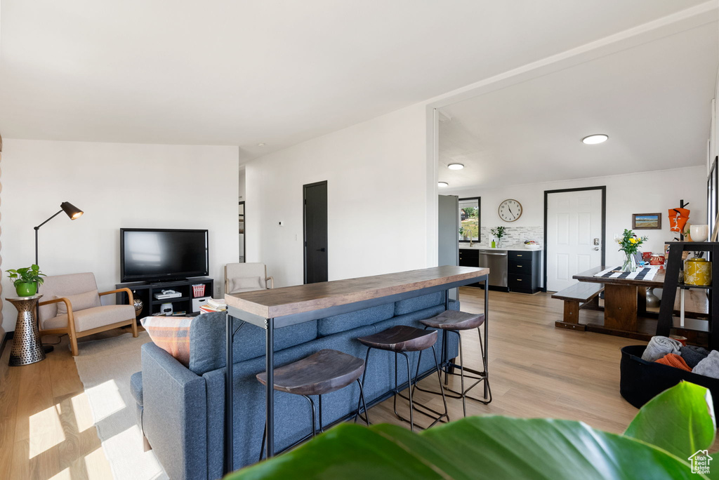 Living room with light wood finished floors and recessed lighting