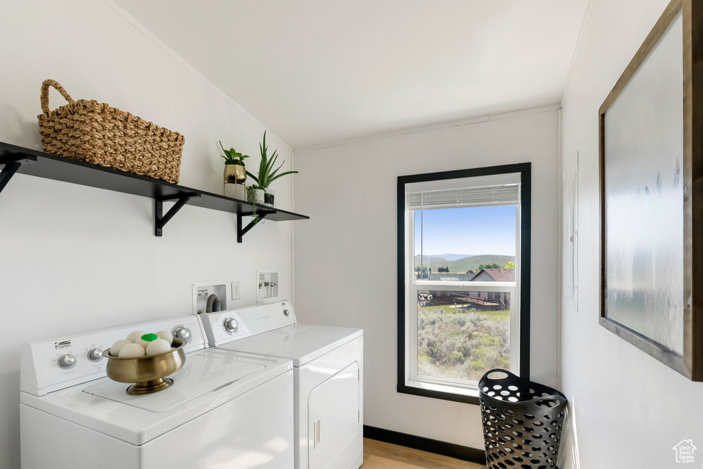 Laundry area with washing machine and dryer and light wood-style flooring