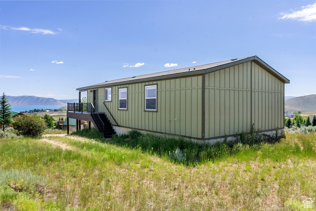 View of side of property with board and batten siding, stairway, and a deck with mountain view