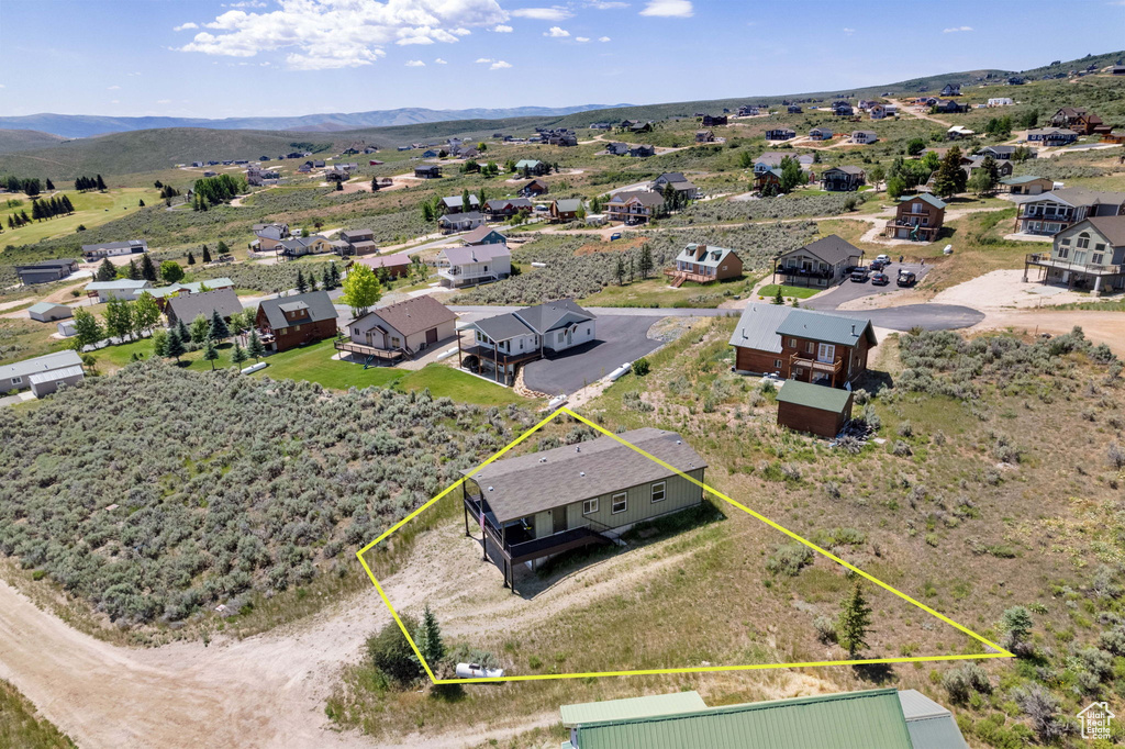 Aerial perspective of suburban area featuring property boundaries highlighted and mountains