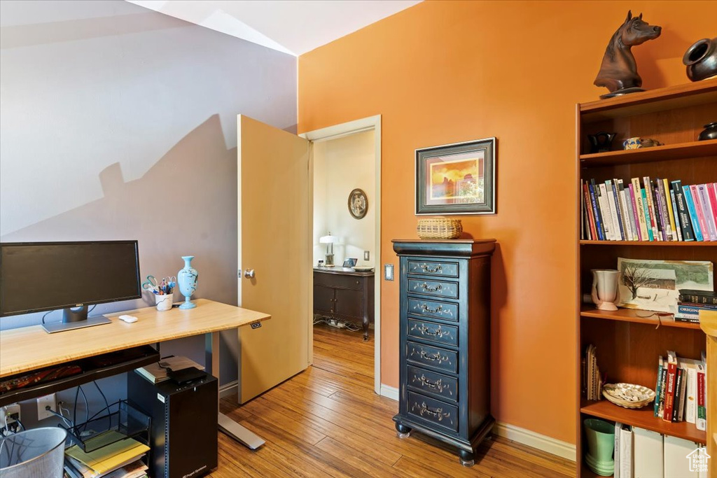 Office space featuring wood finished floors and lofted ceiling