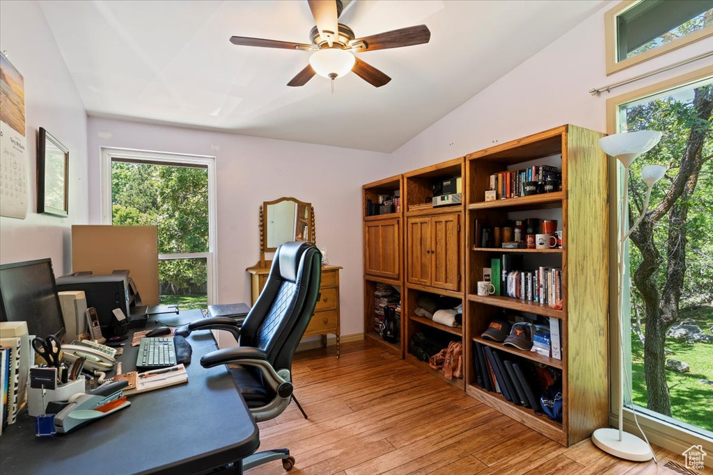 Office area with vaulted ceiling, light wood-style floors, and a ceiling fan