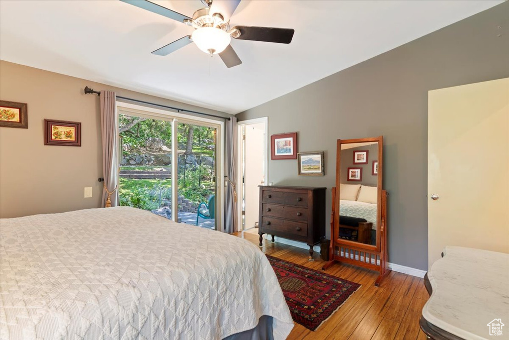 Bedroom with hardwood / wood-style flooring, access to exterior, ceiling fan, and lofted ceiling