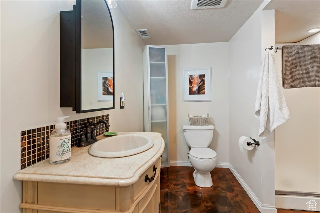 Bathroom with vanity, a shower stall, and decorative backsplash