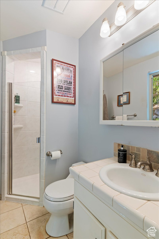 Full bath featuring vanity, a stall shower, and tile patterned floors