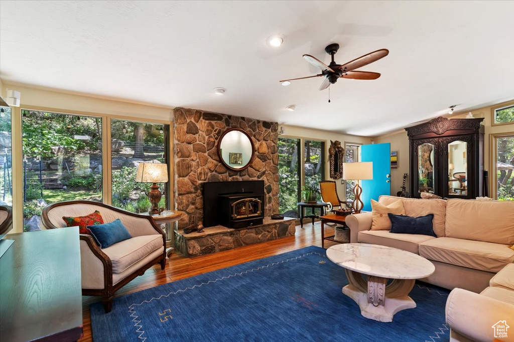 Living room with wood finished floors, a ceiling fan, and healthy amount of natural light