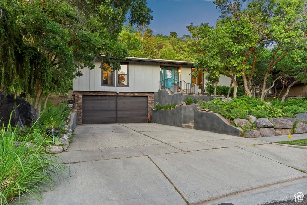 View of front of home with driveway, an attached garage, and brick siding