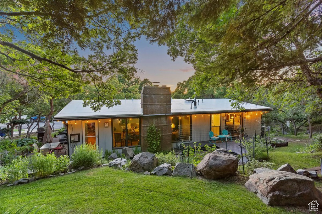 View of front of house with a lawn, a chimney, and a porch