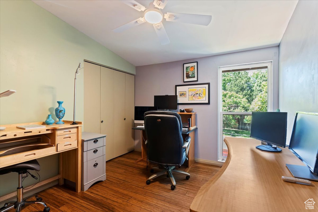 Home office featuring dark wood-style flooring, ceiling fan, and vaulted ceiling