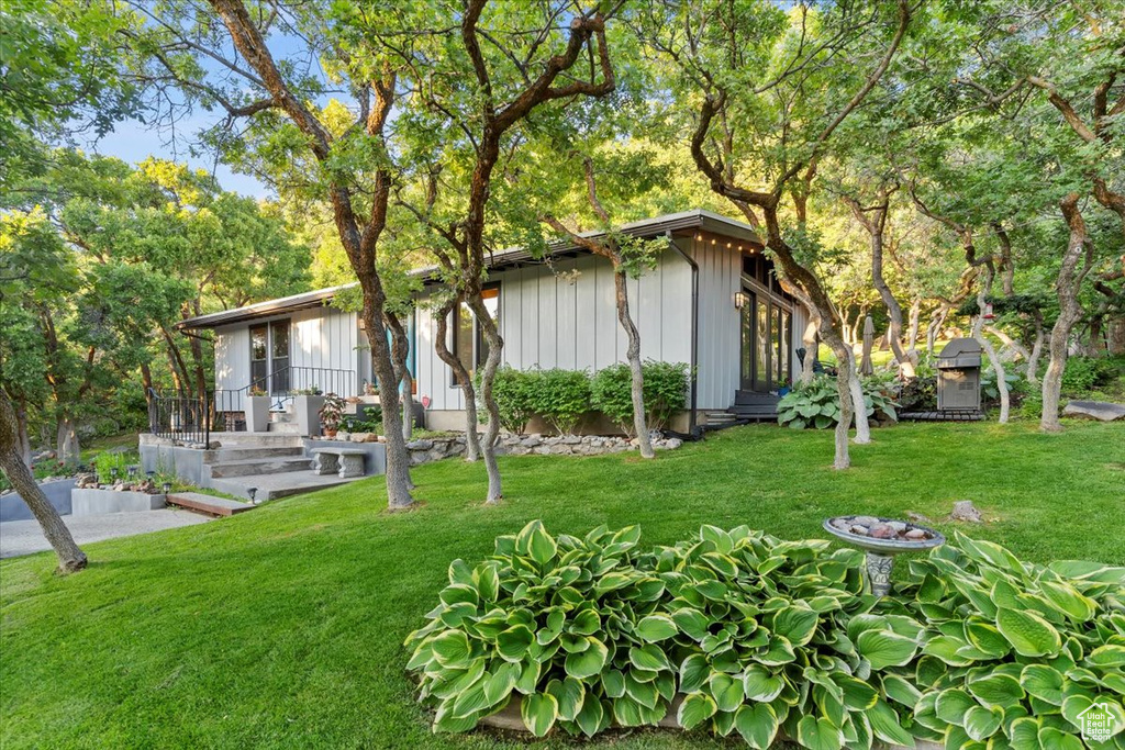 View of front of home featuring board and batten siding and a front lawn