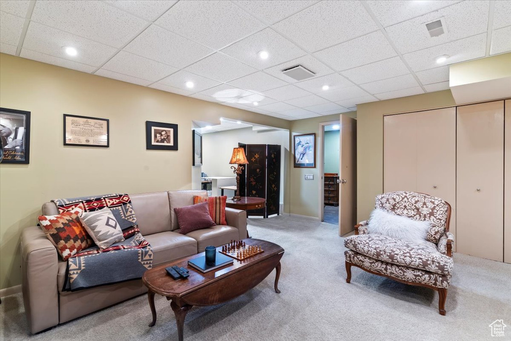Living room with light colored carpet, a paneled ceiling, and recessed lighting