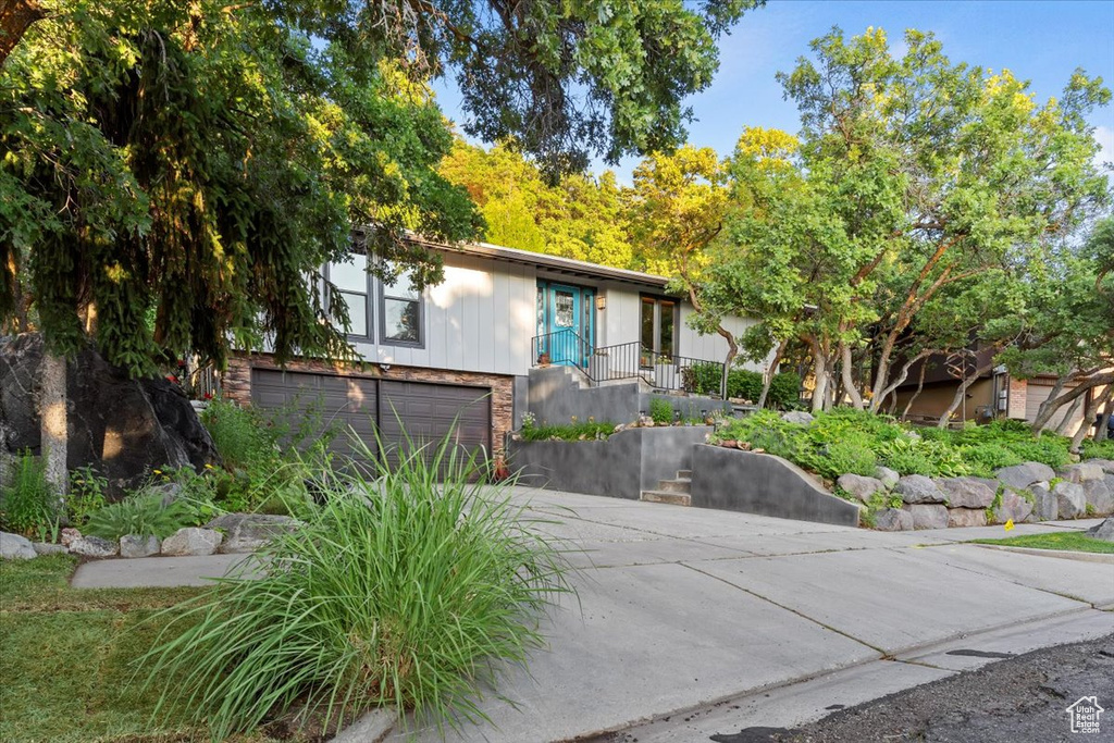 View of front of home featuring concrete driveway, an attached garage, and brick siding