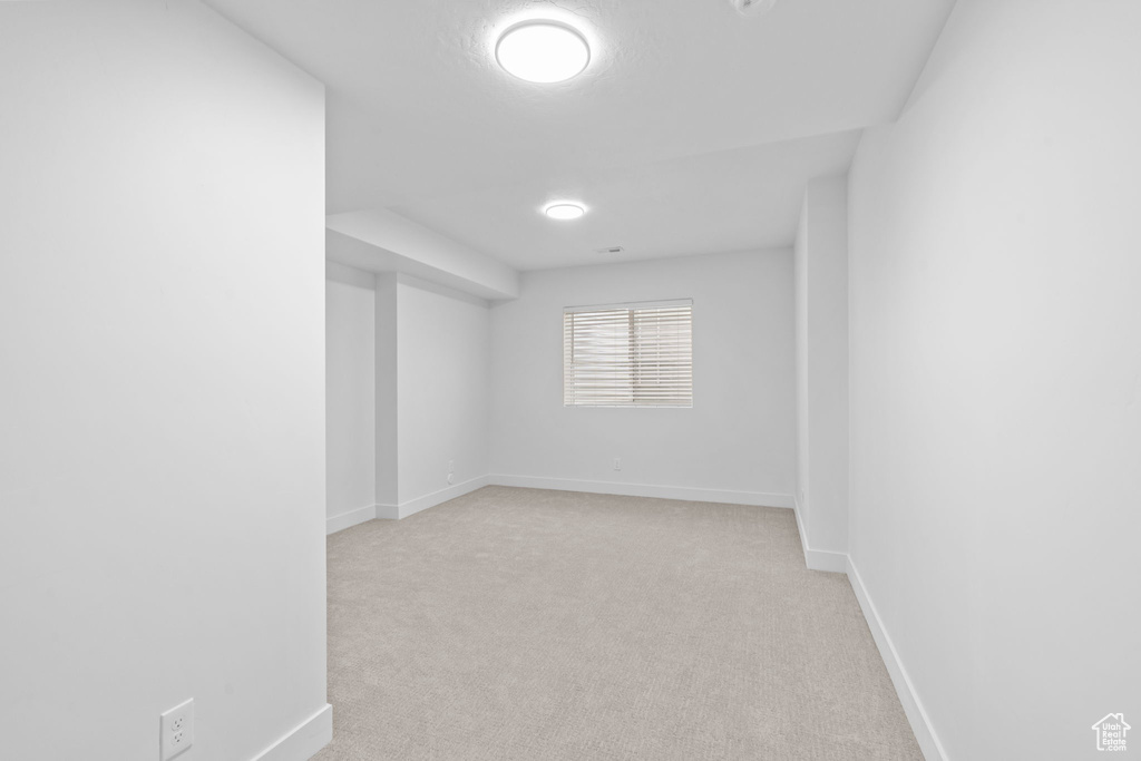 Spare room with light colored carpet and baseboards