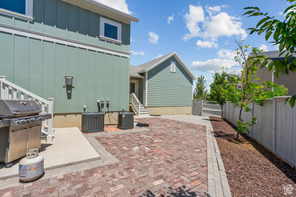 Fenced backyard with a grill, entry steps, and a patio area