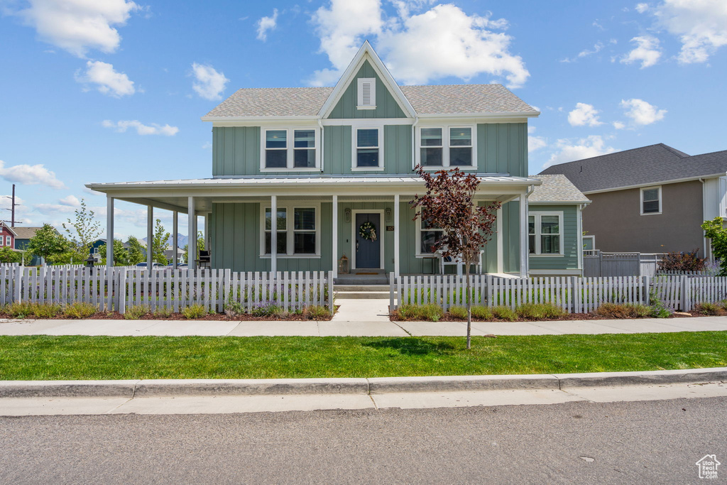 View of front of property with board and batten siding, a porch, and a shingled roof