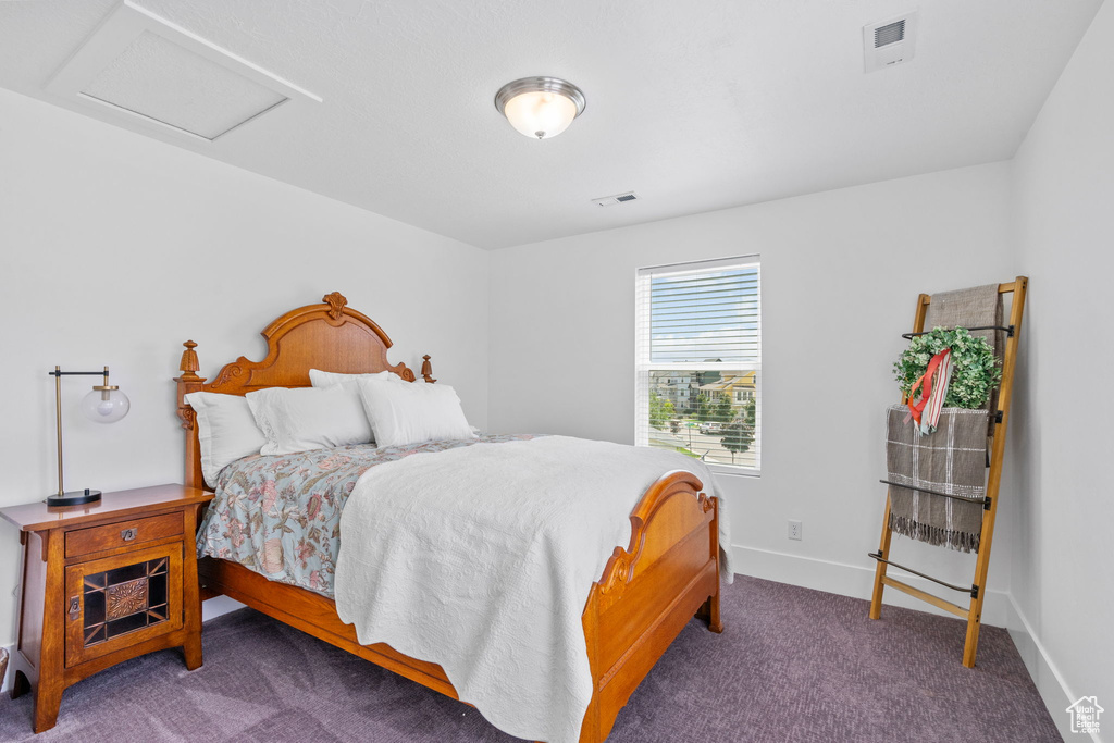 Carpeted bedroom with attic access and baseboards