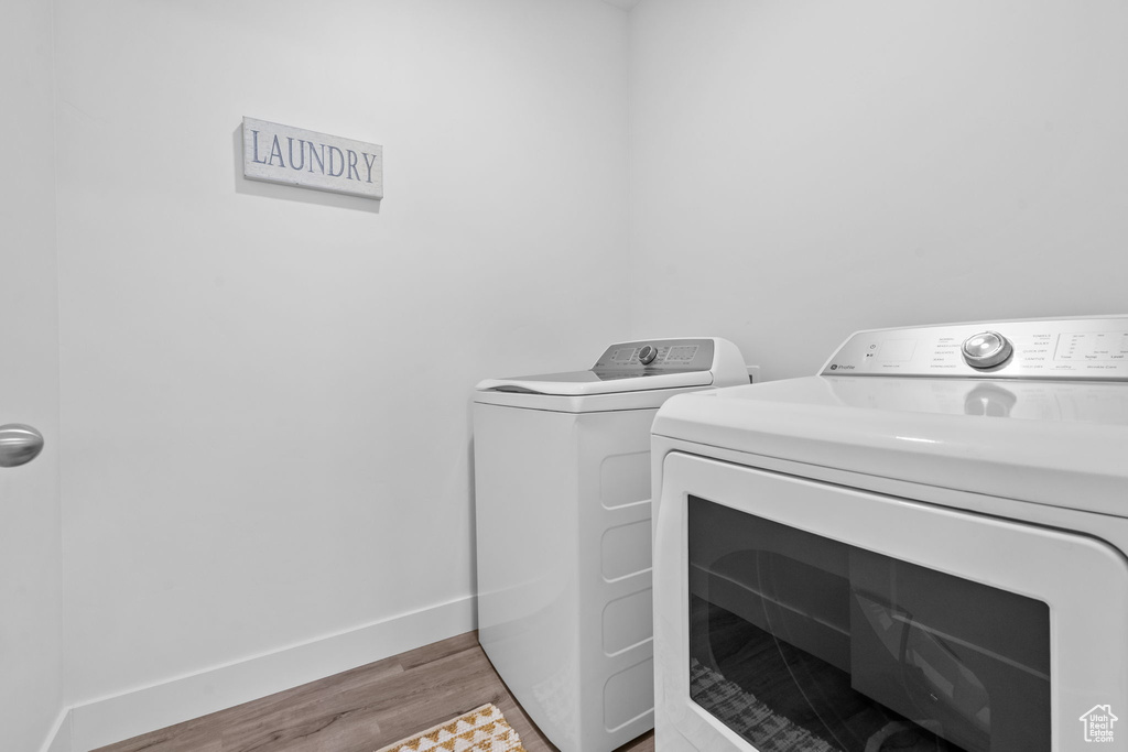 Laundry room with separate washer and dryer and light wood finished floors