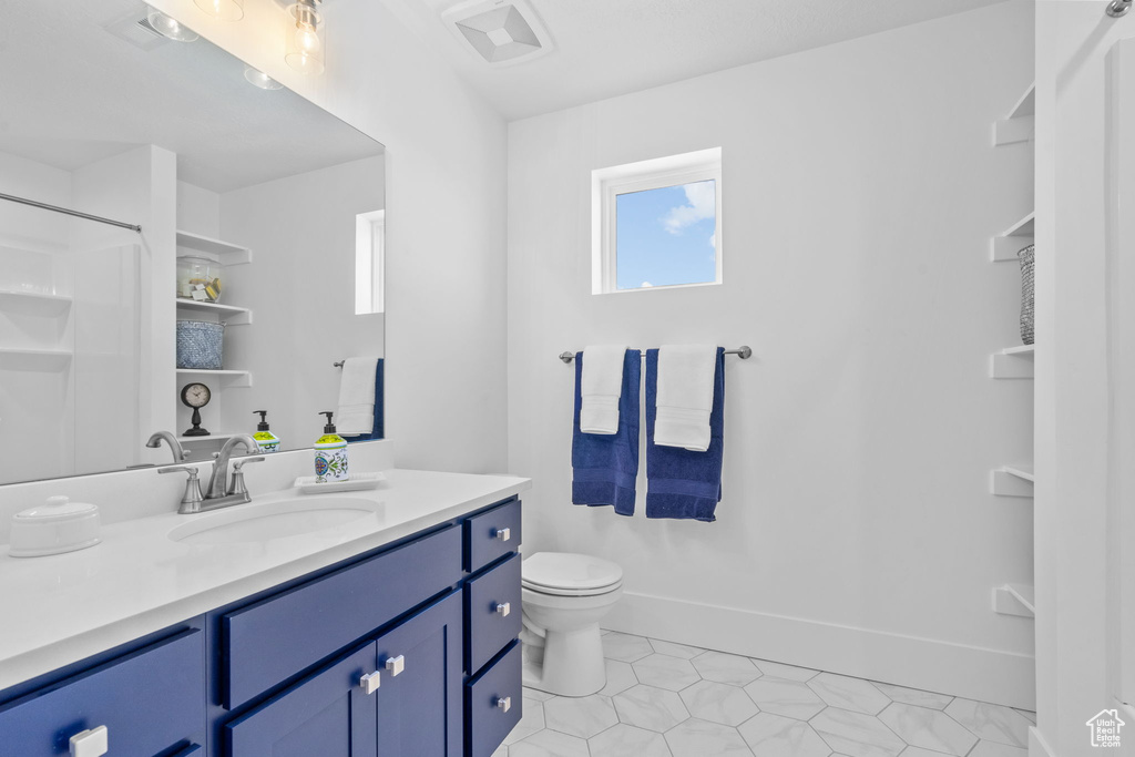Bathroom featuring vanity, tile patterned flooring, and a shower