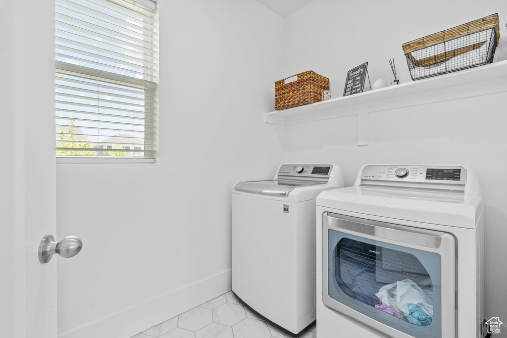 Washroom featuring independent washer and dryer and baseboards