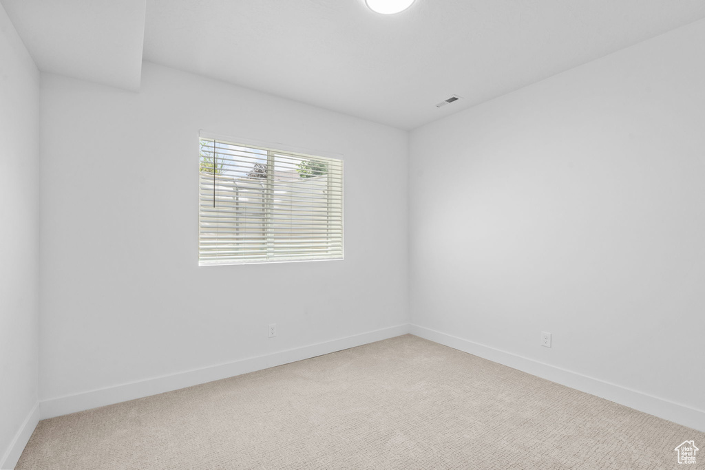 Carpeted empty room featuring baseboards