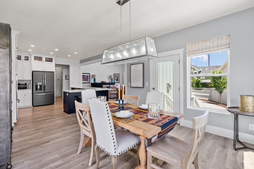 Dining area with light wood-style floors and recessed lighting