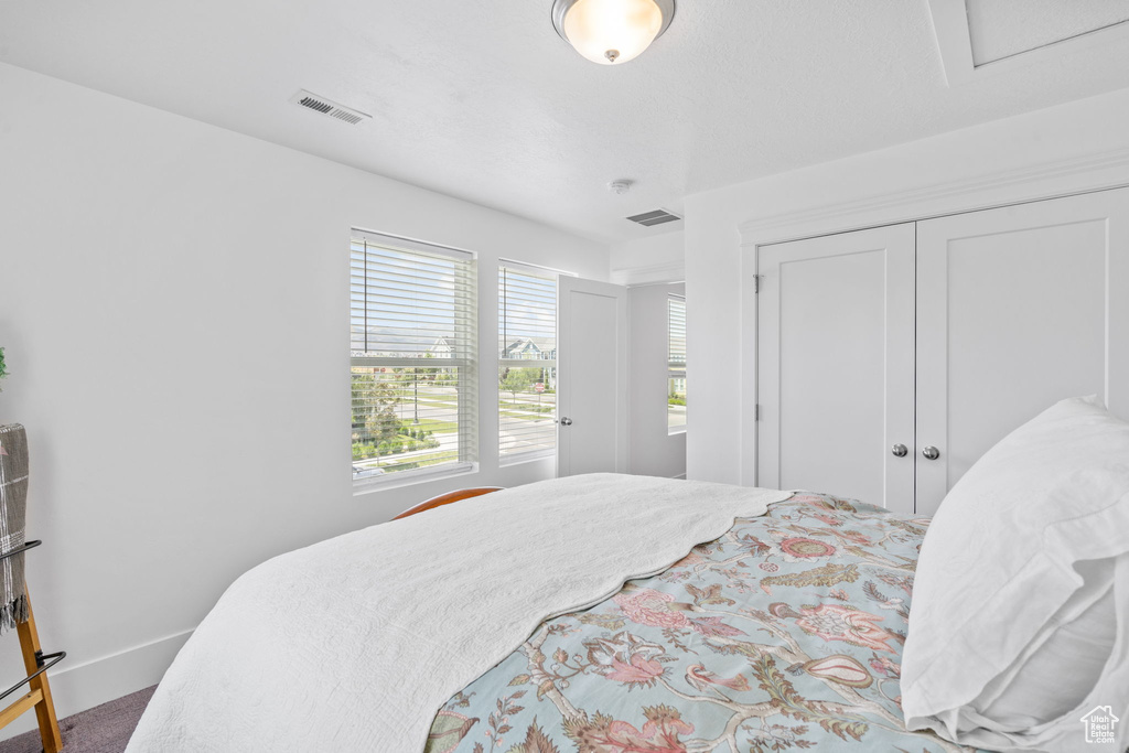 Bedroom featuring carpet flooring and a closet