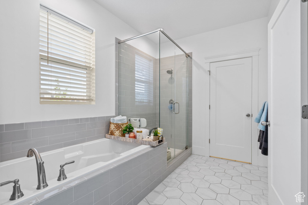 Full bath featuring a bath, a shower stall, and tile patterned flooring