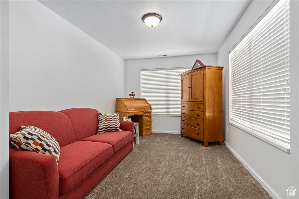 Sitting room with light colored carpet and baseboards