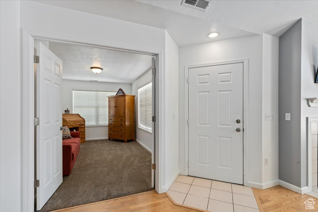 Entrance foyer featuring light wood-style floors and a textured ceiling