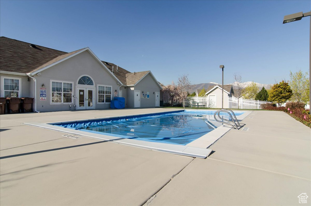 View of pool featuring french doors, a patio area, and a storage shed