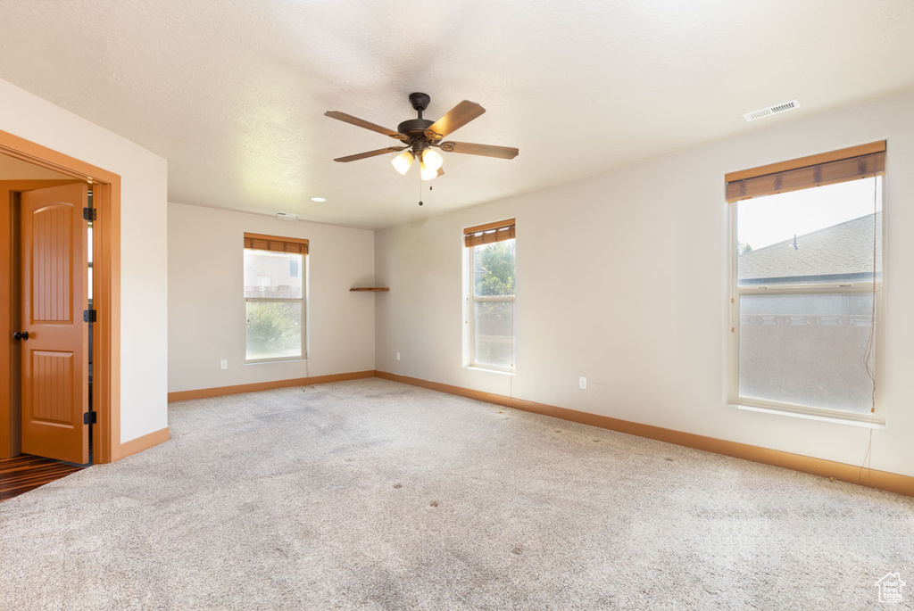 Spare room with a ceiling fan and carpet flooring
