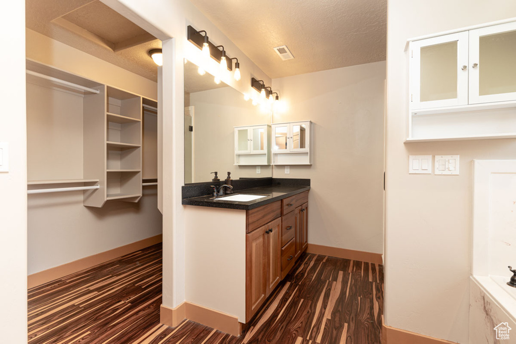 Bathroom with vanity, wood finished floors, and a textured ceiling