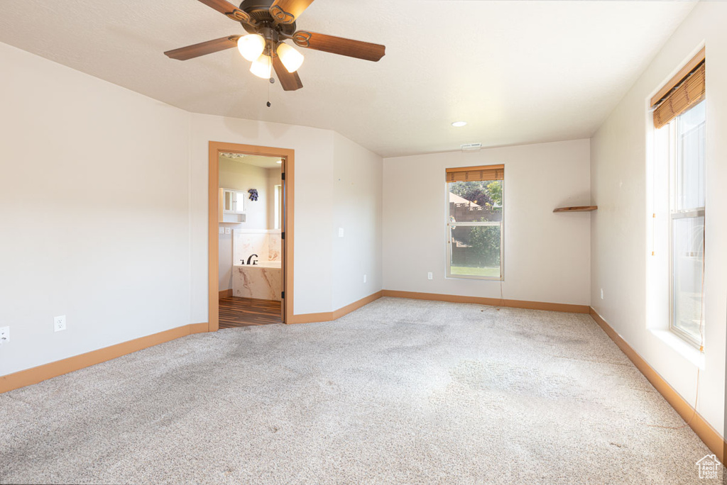 Empty room with light colored carpet and a ceiling fan
