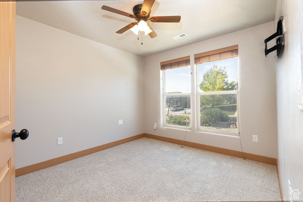 Unfurnished room with carpet floors and a ceiling fan