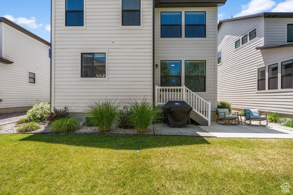 Rear view of house with a yard and a patio area