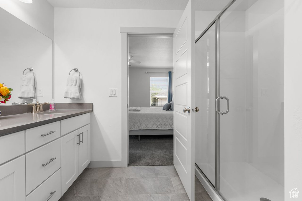 Full bathroom featuring ensuite bath, vanity, and a shower stall