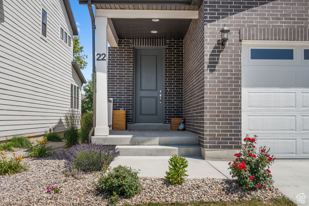 Entrance to property featuring brick siding and an attached garage