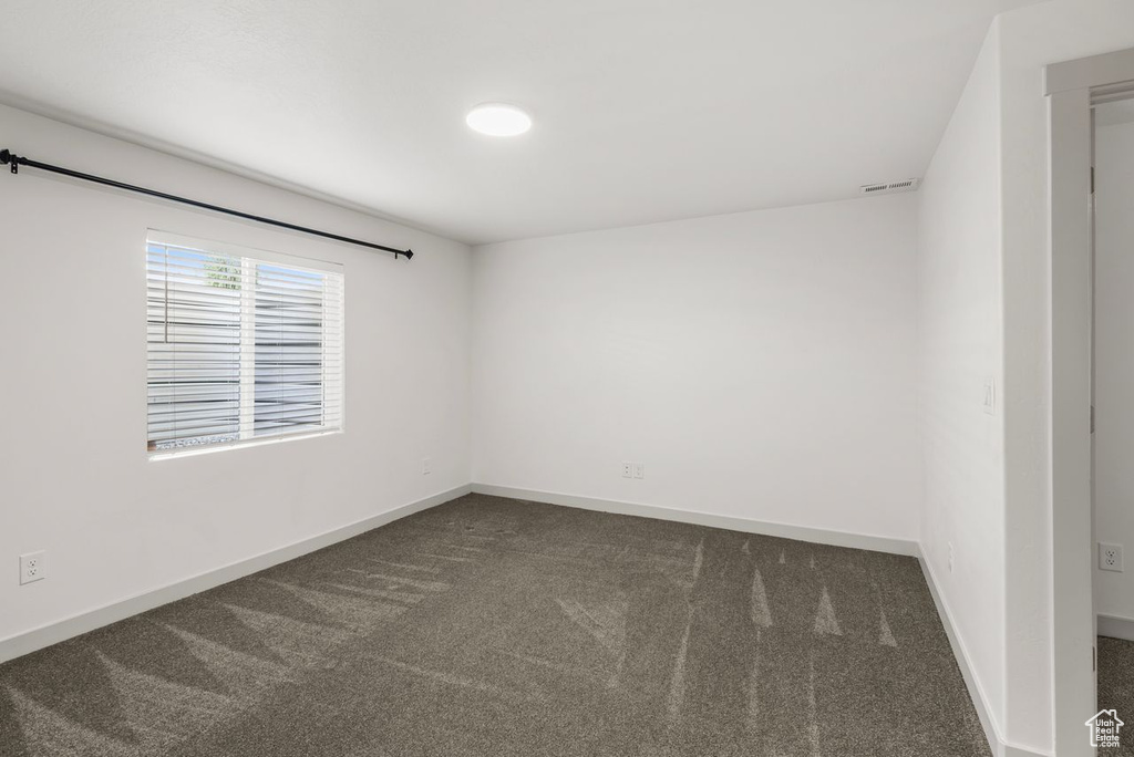Empty room with dark colored carpet