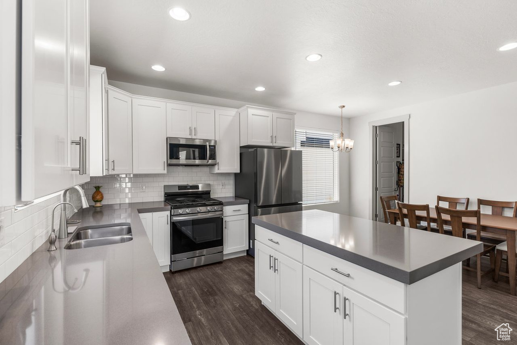 Kitchen with appliances with stainless steel finishes, dark wood finished floors, decorative backsplash, dark countertops, and recessed lighting