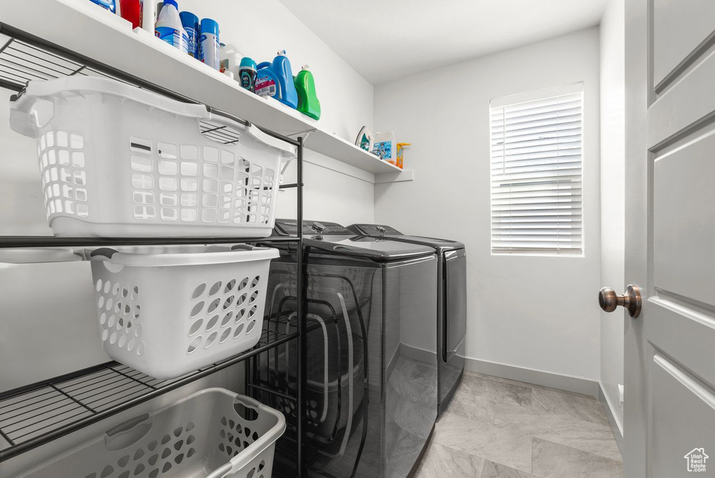 Washroom with washer and dryer and baseboards