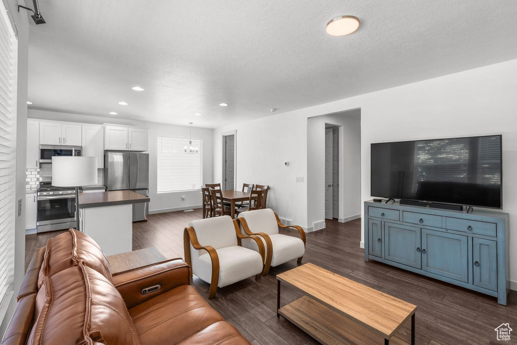 Living area featuring recessed lighting, a chandelier, and dark wood-style floors