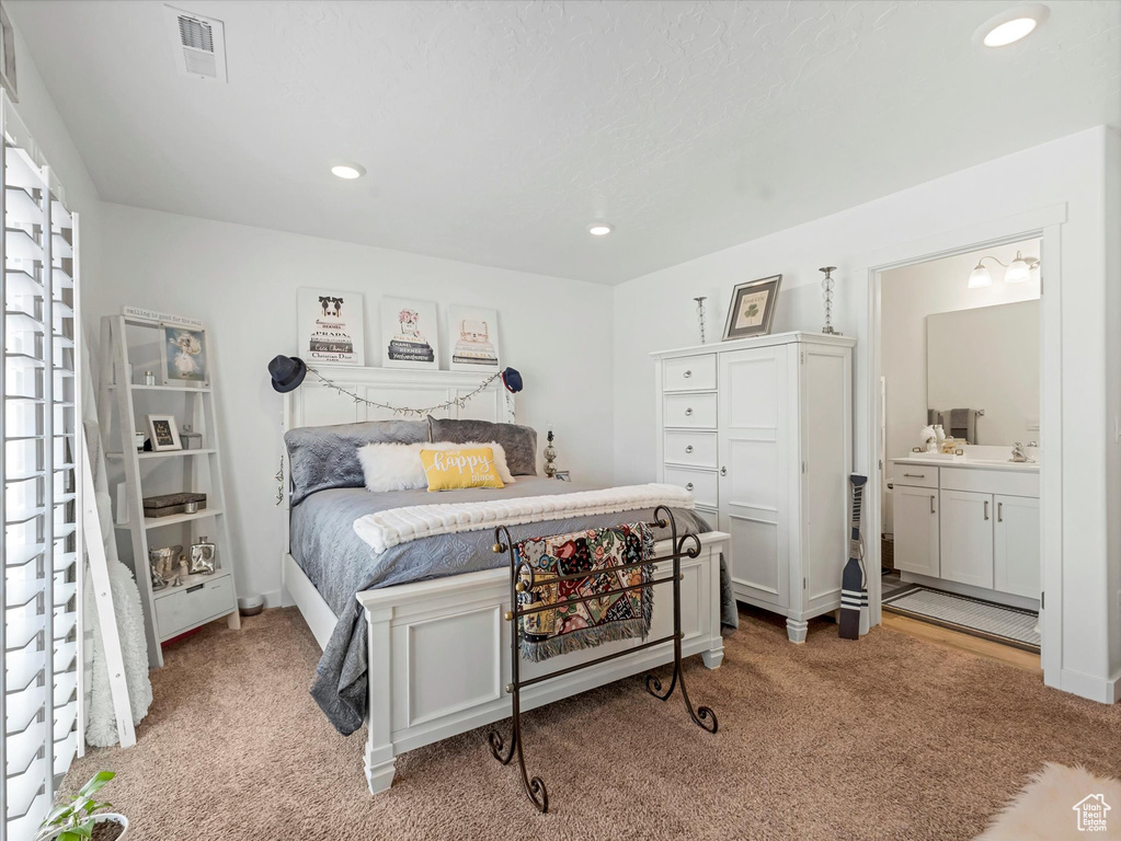 Carpeted bedroom with recessed lighting and connected bathroom