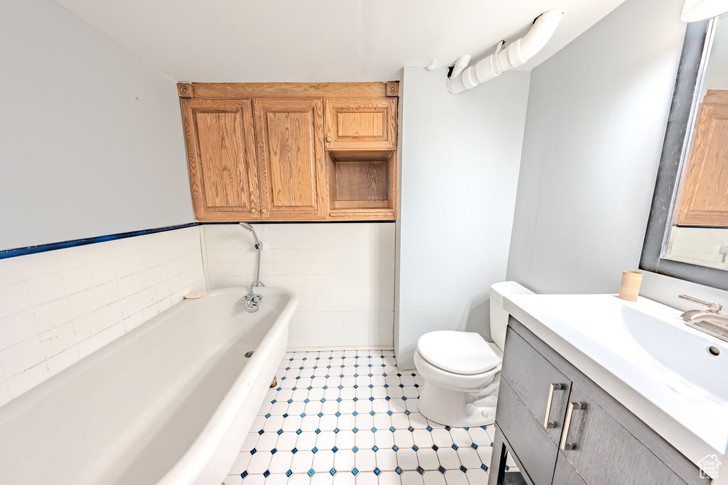 Full bath featuring a bath, vanity, and tile patterned floors