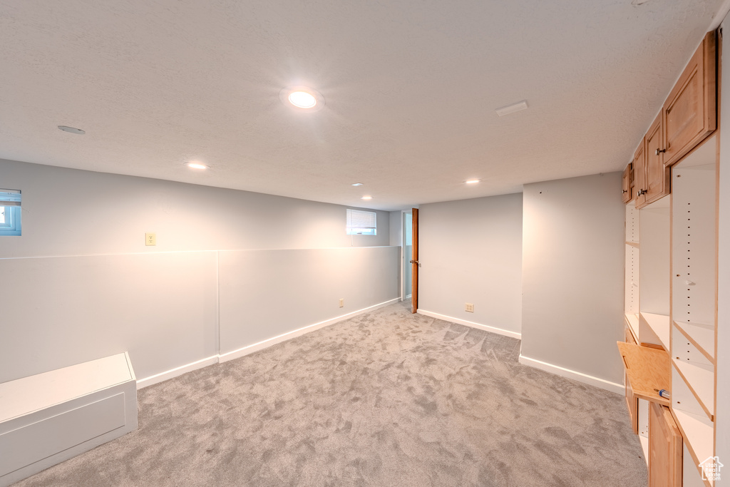 Below grade area featuring light colored carpet and recessed lighting
