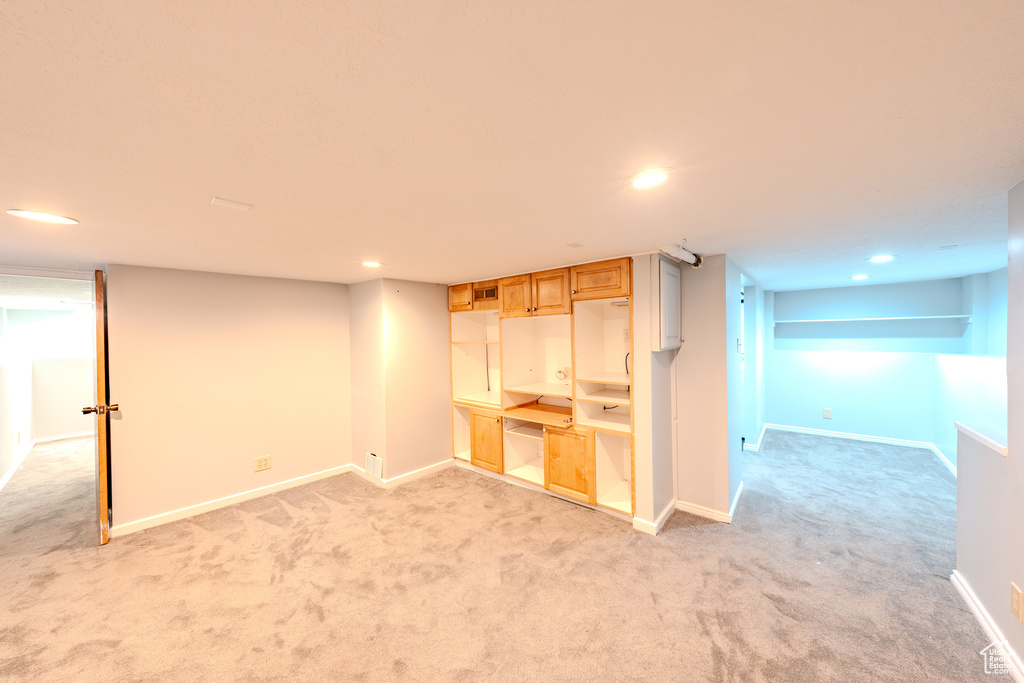 Finished below grade area featuring light carpet and recessed lighting