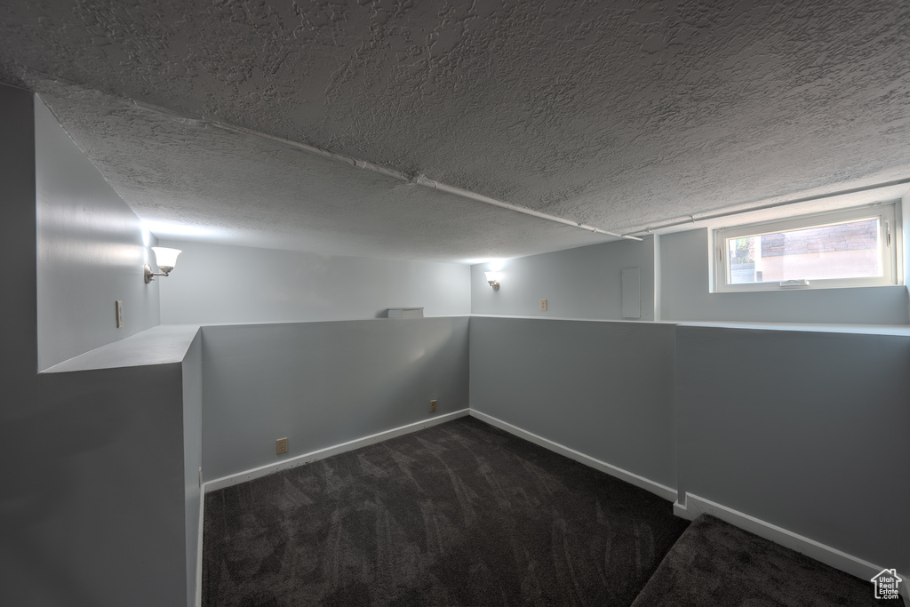Carpeted spare room with baseboards and a textured ceiling