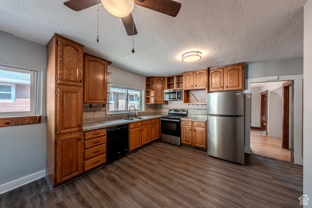 Kitchen featuring appliances with stainless steel finishes, open shelves, a textured ceiling, tasteful backsplash, and dark wood-style floors