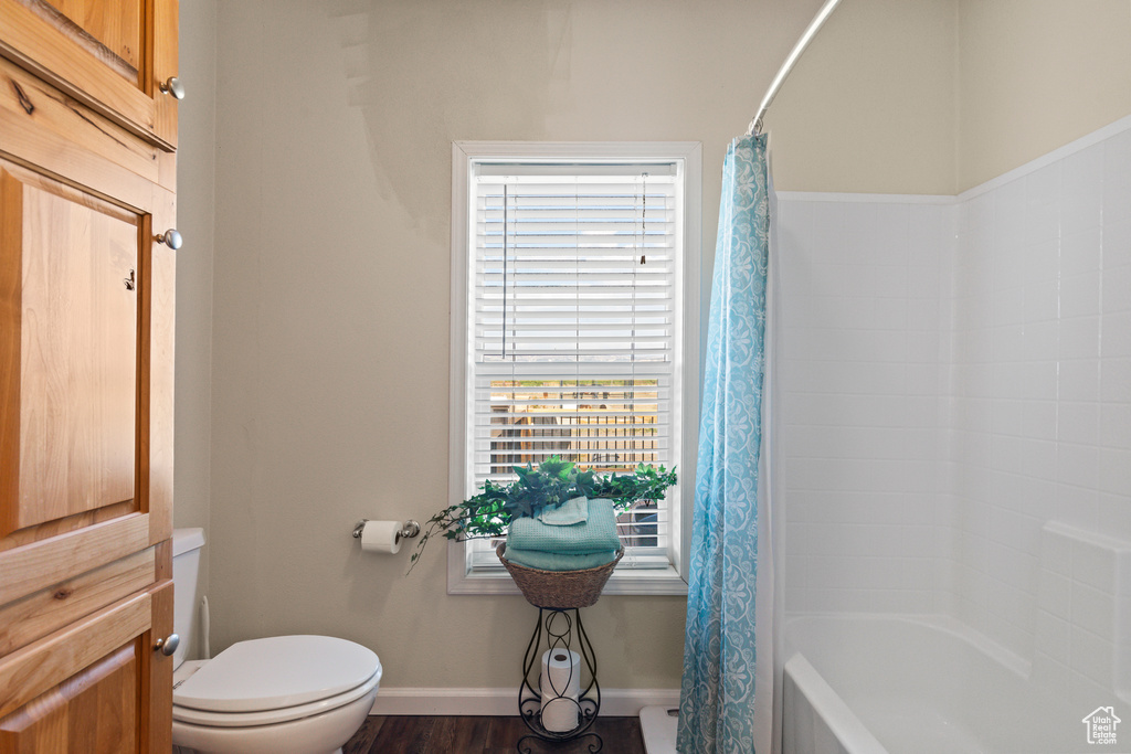 Bathroom featuring shower / tub combo and wood finished floors